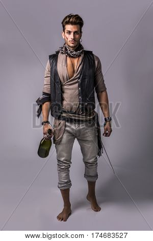 Good Looking Young Man in Pirate Fashion Outfit on Gray Background. Captured in Studio.