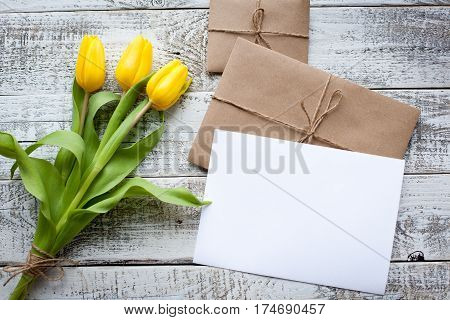 Fresh Yellow Tulips And Empty Tag On Teal Painted Wooden Background. Selective Focus. Place For Text