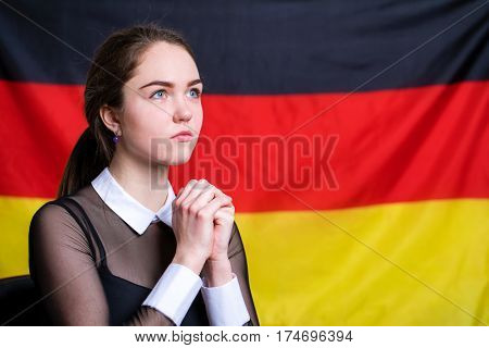 Portrait of a beautiful calm brunette girl in the background of the German flag