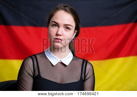 Portrait of a beautiful calm brunette girl in the background of the German flag