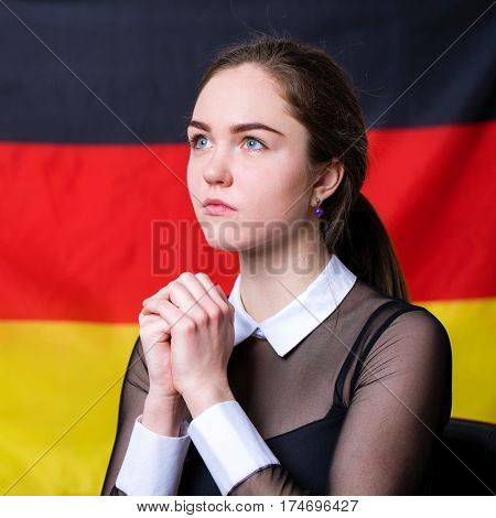 Portrait of a beautiful calm brunette girl in the background of the German flag