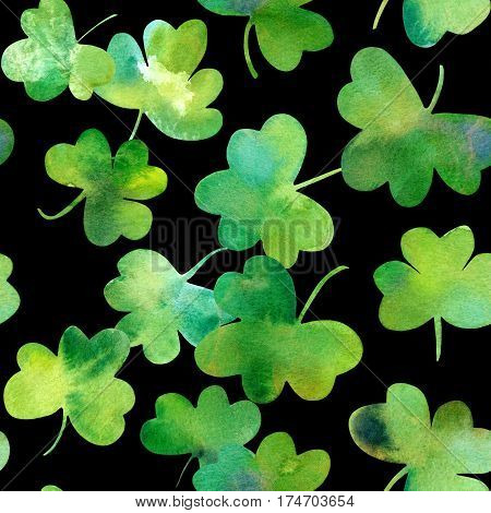 A seamless background pattern with hand drawn watercolour shamrocks on a black background