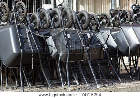 diferent types of black wheelbarrows ready to sell tied with string
