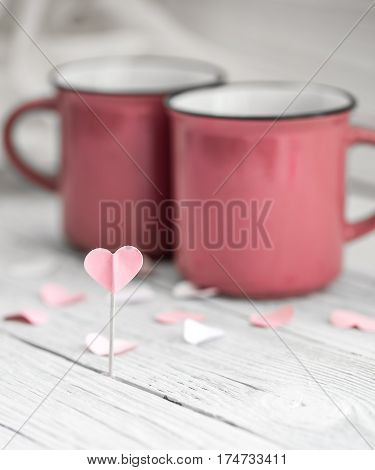 beautiful pink Cup with heart on a stick on a light wooden background, concept drinks
