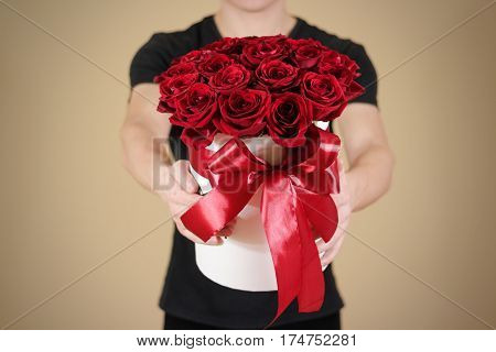 Man In Black T Shirt Holding In Hand Rich Gift Bouquet Of 21 Red Roses. Composition Of Flowers In A