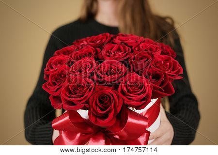 Girl In Black Jacket Holding In Hand Rich Gift Bouquet Of 21 Red Roses. Composition Of Flowers In A