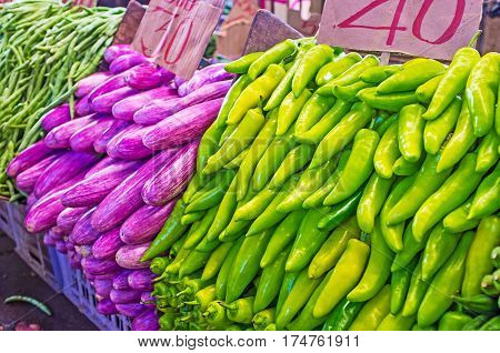 The vegetable stall in Fose Market - heaps of bright green peppers and purple eggplants Colombo Sri Lanka.