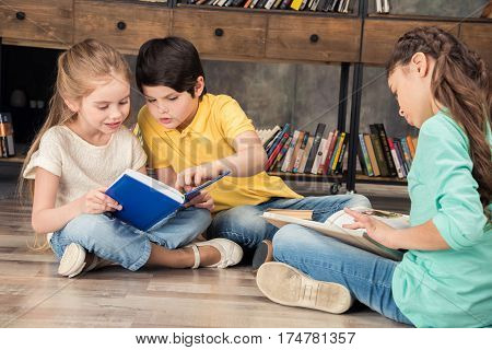 concentrated boy and girls reading books in library