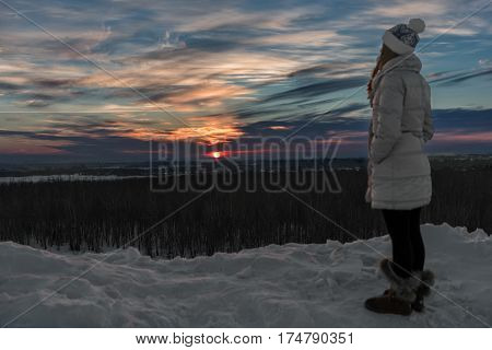 Girl out of focus, looking at the sunset