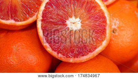 Oranges And An Orange Cut In The Stall Of Greengrocer