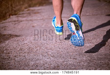 Foot closeup athlete running in sneakers outdoors.