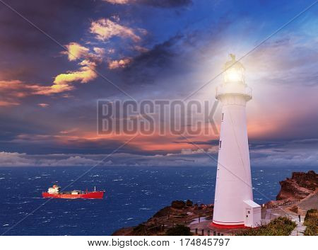 Sunset seascape, lighthouse on the bluff