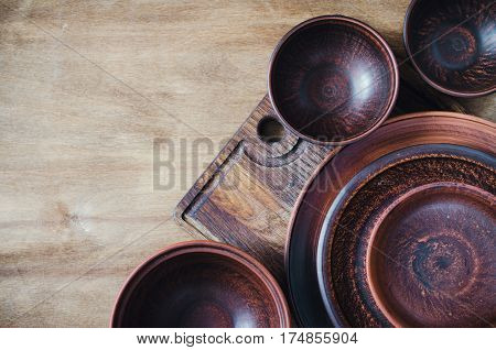 Rustic Kitchen Utensils: the Ceramic Plates and Wooden Cutlery on Wooden Background. Home Wares. Kitchen Decor in Rustic Style. View From Above With Copy Space.