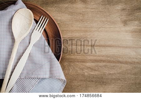 Rustic Kitchen Utensils: the Ceramic Plates and Wooden Cutlery on Wooden Background. Home Wares. Kitchen Decor in Rustic Style. View From Above With Copy Space.