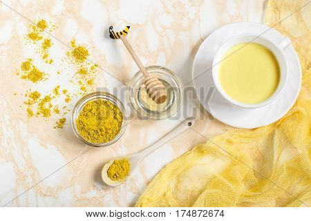 Healthy drink: milk with turmeric and honey known as the golden milk. Detox burns fat boosts immunity disease prevention. Flat lay top view