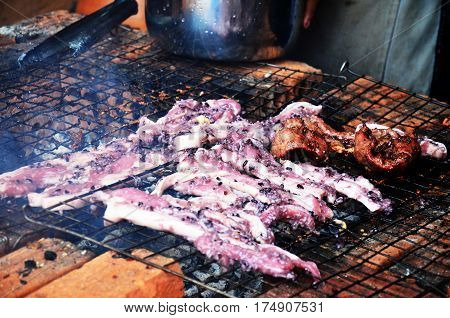 Laotian People Cooking Pork Roasted And Entrails Of Pig Grilled For Sale On Old Stove