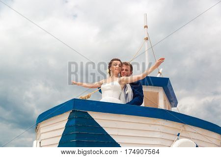 Wedding couple on small boat. The bride and groom on the ship.