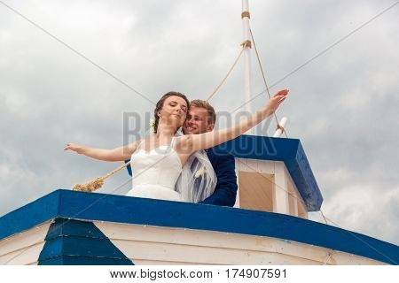 Wedding couple on small boat. The bride and groom on the ship.