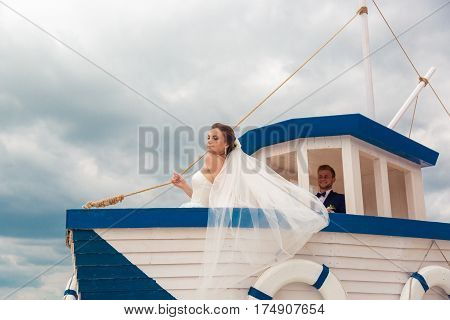 Wedding couple on small boat. The bride and groom on the ship.