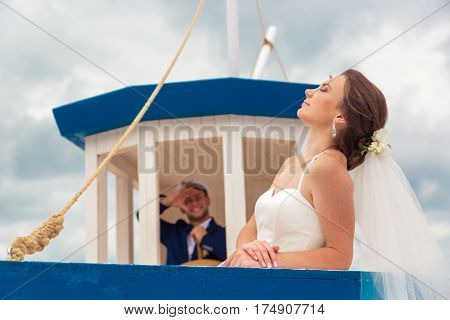 Wedding couple on small boat. The bride and groom on the ship.