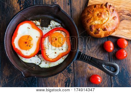 Fried Eggs And Bell Pepper In Black Iron-cast Skillet, Fresh Tomatoes And Bread. Top View.