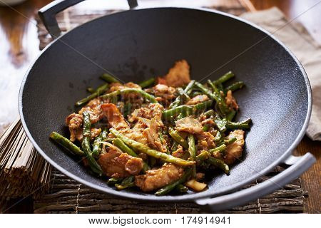 cooked string bean chicken inside large asian wok