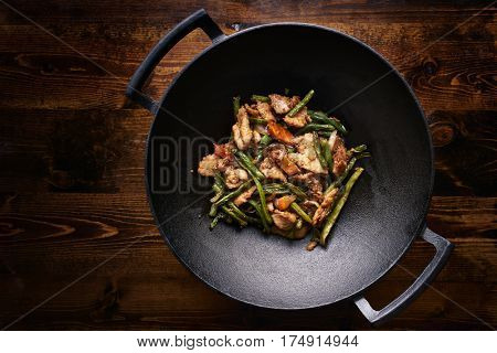 stir fried chicken in cast iron wok in flat lay composition