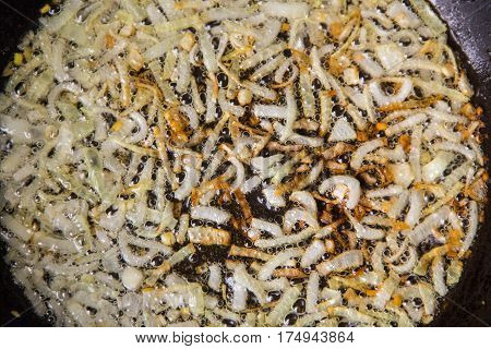 The process of frying the onions in a hot pan in vegetable oil