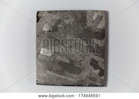 Iron meteorite piece on a white background.
