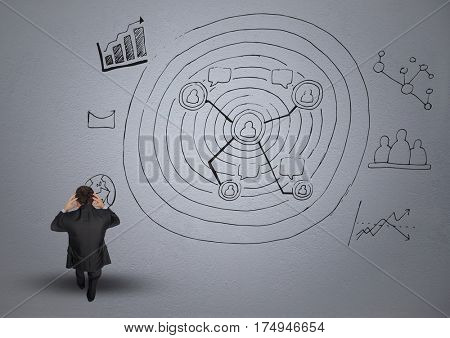 Digital composite image of frustrated businessman and business graphics against grey background
