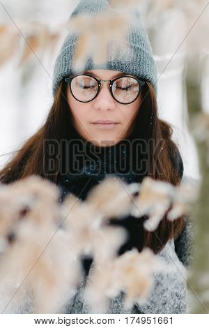 portrait of the brunette in glasses gray coat with a backpack