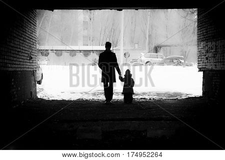 a man holds the hand of a girl winter background silhouette family