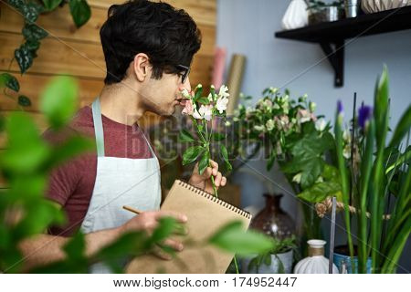 Young man enjoying nice smell of flower