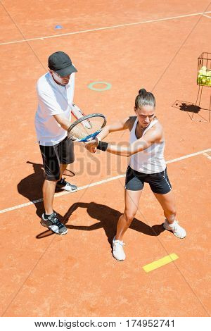 Tennis class - instructor working with young woman