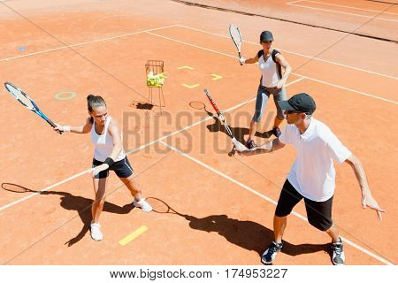 Tennis instructor explaining forehand on training, summer time,  color image