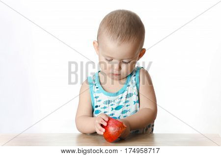 Baby eats a pomegranate ripe and juicy very tasty and joyfully