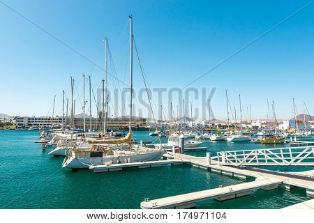 Few yachts in the habror of Lanzarote, distant city in the background, Splain