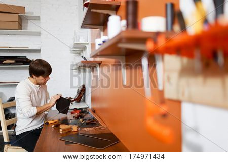 Young professional tanner working in his own atelier
