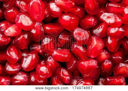 Grains of ripe juicy pomegranate on a black background. Close-up