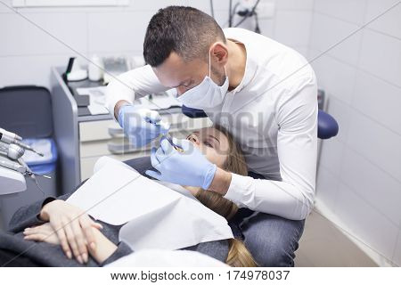 Doctor dentist treats teeth of a beautiful young girl patient. The girl on reception at the dentist. Doctor dentist treats tooth.