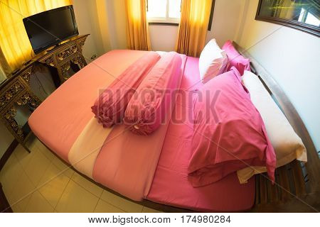 Pink king size bed in apartment, fisheye lane