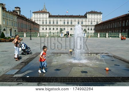 Childern Plying With A Ball On A Fountain