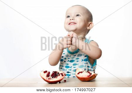 Baby eats a pomegranate ripe and juicy very tasty and joyfully
