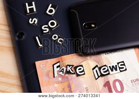 The Concept Of Mobility News: Tablet, Touch Phone, Money And Cutting From The Text With Letters
