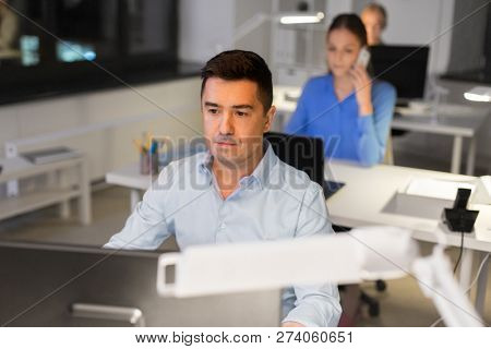 business, deadline and technology concept - man with computer working late at night office