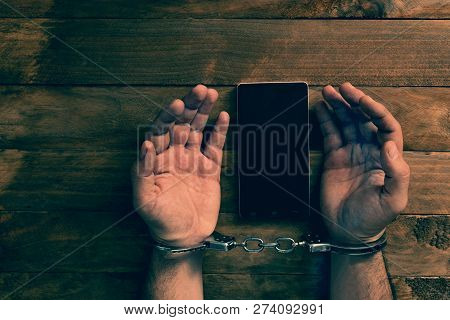 Crime Concept In The Network. Shaking Hands Holding A Mobile Phone.