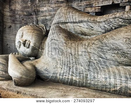 A Reclining Figure Of Buddha Is Carved Into The Stone Cliffs At The Historic Landmark Of Gal Vihare 