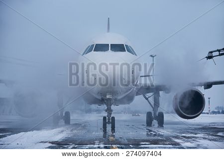 Winter Day At The Airport. Deicing Of Airplane Before Flight.