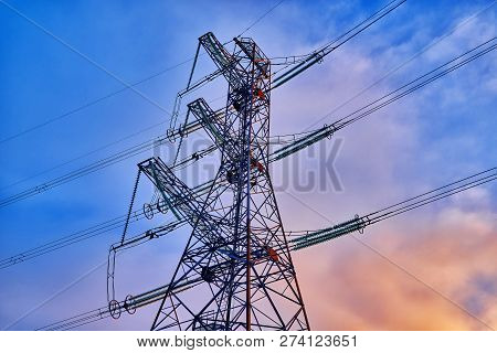 A Transmission Tower Or Electricity Pylon With Blue Sky. It Is A Tall Structure, Usually A Steel Lat