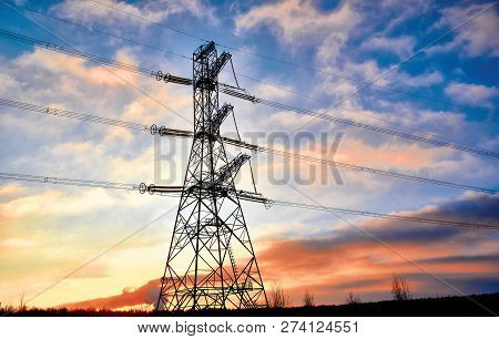 A Transmission Tower Or Electricity Pylon With Blue Sky. It Is A Tall Structure, Usually A Steel Lat